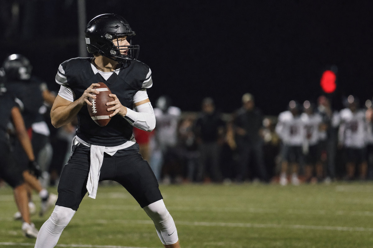 Quarterback under center calling a play during a night game